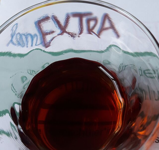Ein Glas mit Chai steht auf dem lernEXTRA Schriftzug.