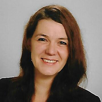 Portrait einer junge Frau mit langem Haar, die freundlich lächelt.