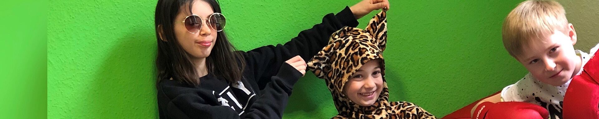 Drei verkleidete Kinder. Ein neunjähriges Mädchen als Topmodel, ein siebenjähriges Mädchen als Leopardin und ein neunjähriger Junge als Boxer. 