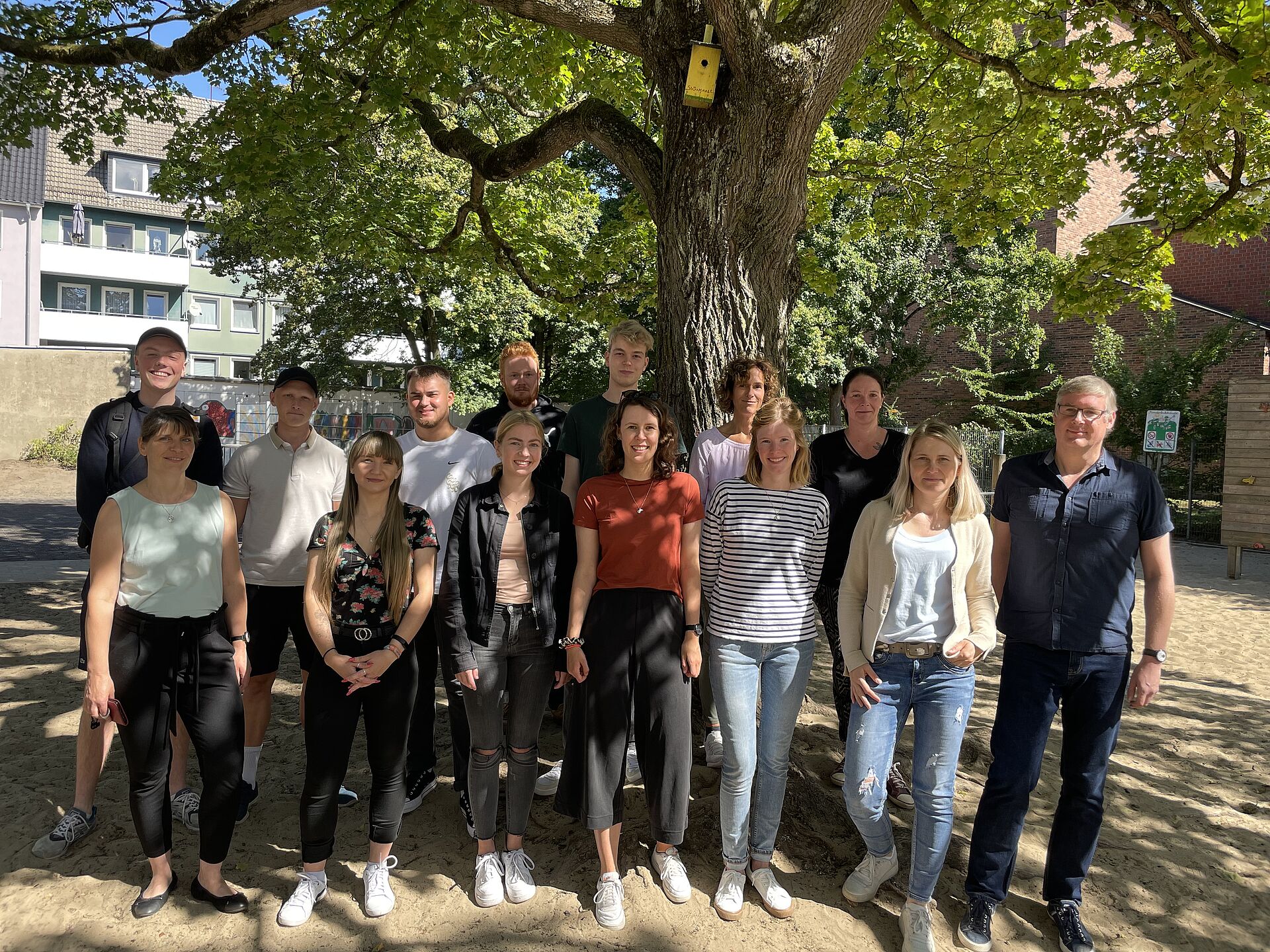 Gruppenfoto des pädagogischen Teams bestehend aus 14 Personen unter einem Ahorn