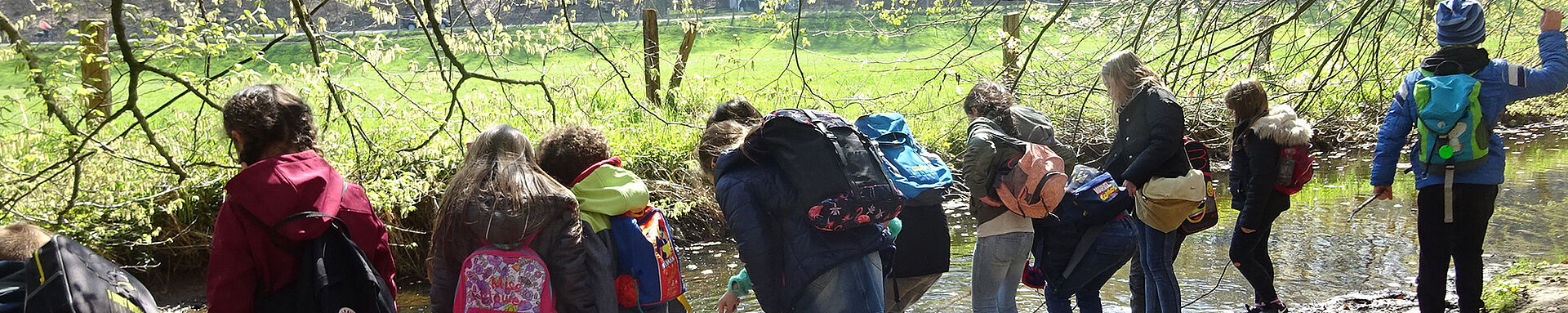 Eine Gruppe der Hortkinder steht am Fluss. 
