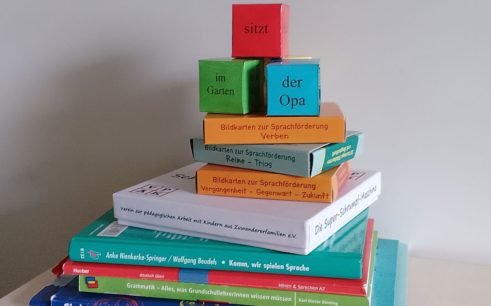 Auf dem Bild ist ein Stapel von Büchern und Sprachförderspielen abgebildet