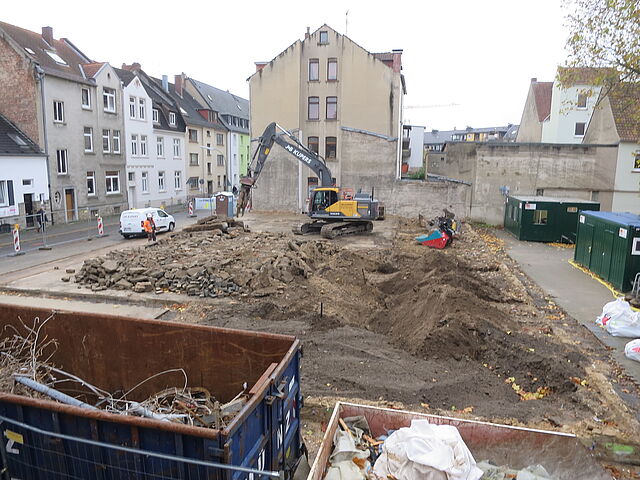 Baukontainer stehen vor einer großen freien Fläche, wo kürzlich noch die Turnhalle stand.